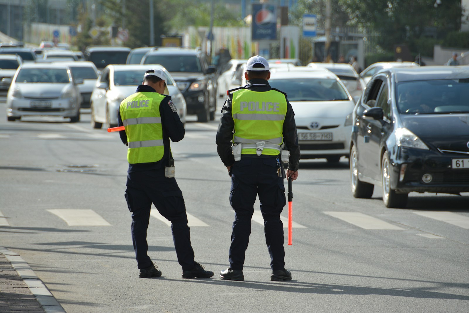 two police officers standing on the side of a road Sicurezza stradale Milano