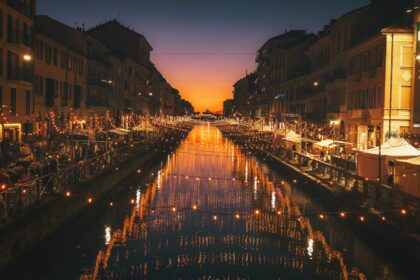 reflective photography of string lights above river weekend Milano