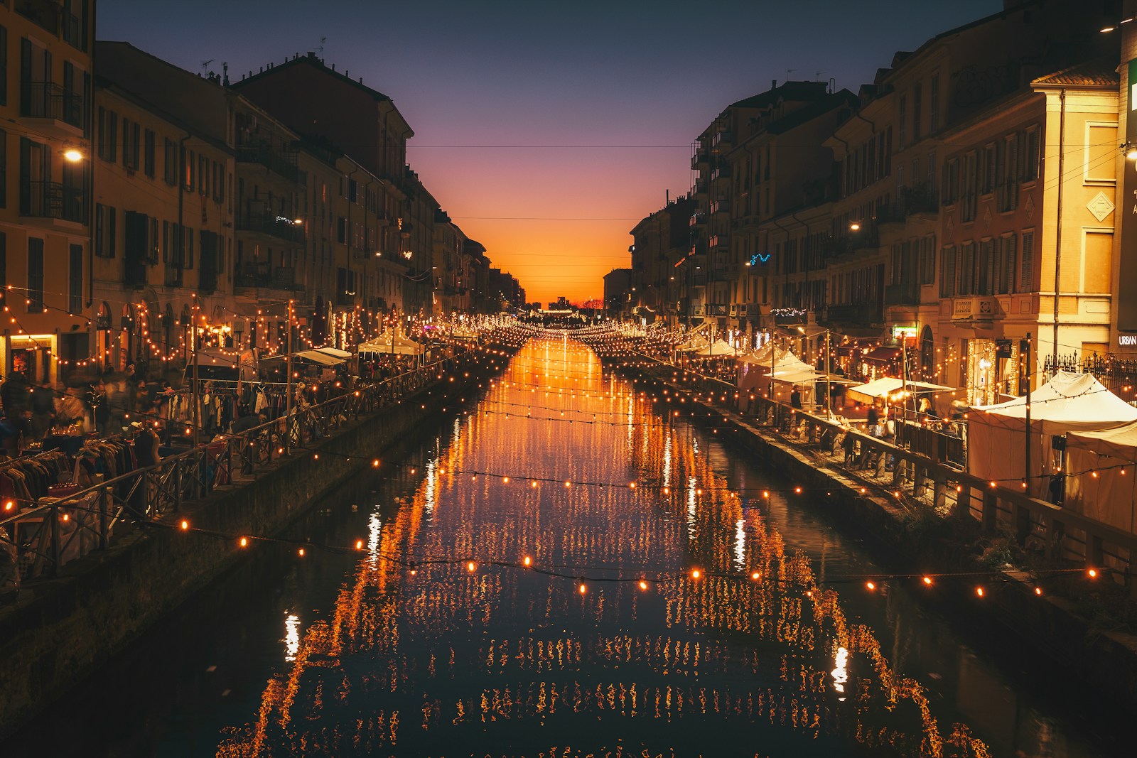 reflective photography of string lights above river weekend Milano