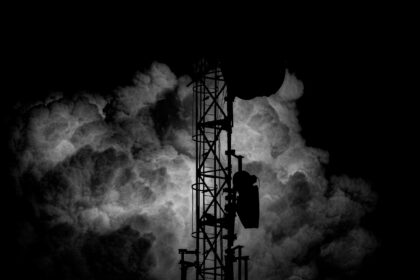 a black and white photo of a tower in the clouds